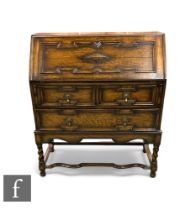 A 1920s oak bureau, the fitted interior enclosed by a geometric moulded front fall over three long