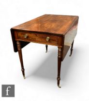 A George III mahogany drop leaf table, raised on turned supports and terminating at brass castors,