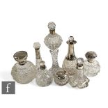 A collection of Victorian and later cut glass silver topped scent bottles and dressing table jars,