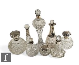 A collection of Victorian and later cut glass silver topped scent bottles and dressing table jars,