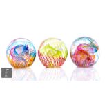 Three contemporary Isle of Wight studio glass paperweights of domed form, all internally decorated