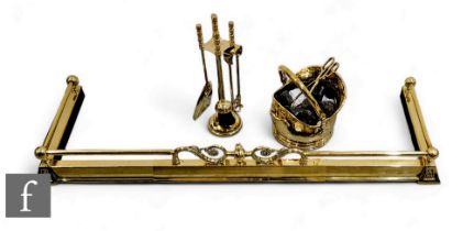 A modern brass fender, length 148cm, a brass coal bucket and a companion set. (3)