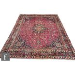 A large Persian Isfahan wool carpet, the red ground with black and blue floral motifs set within