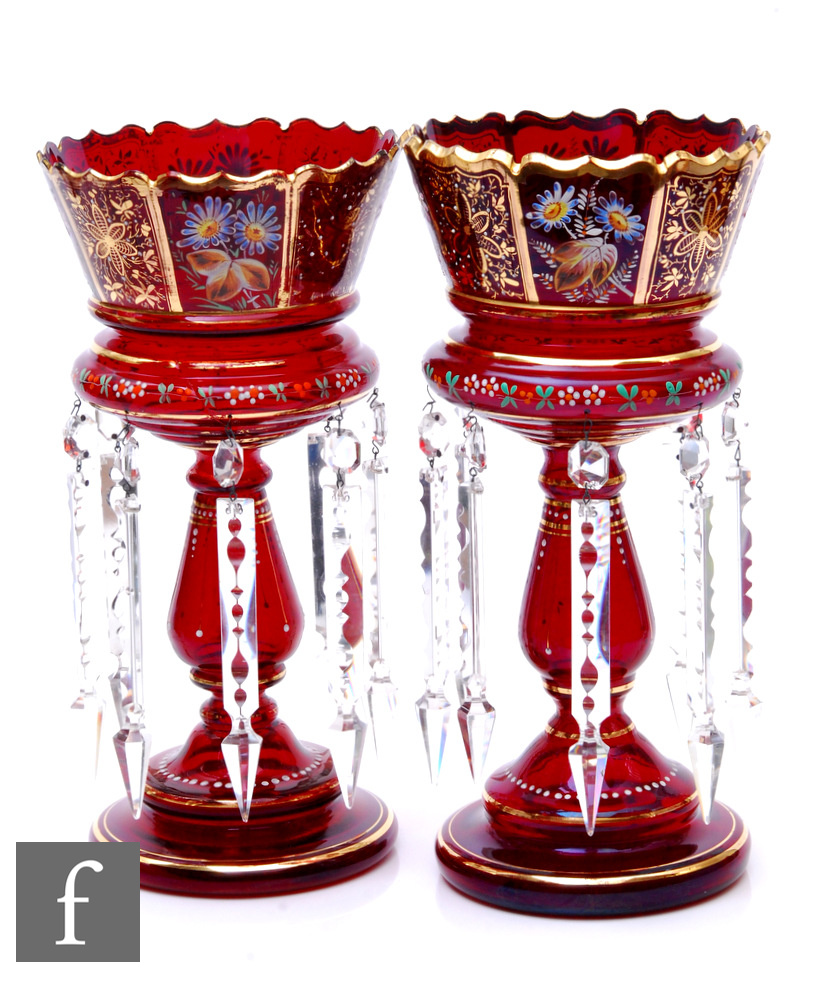 A pair of late 19th Century ruby glass table lustres, each with a stepped circular foot, baluster