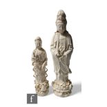 Two Chinese Blanc-de-chine figures of Guanyin, both in standing position, raised on lotus base, each