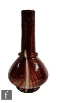 A late 19th Century Loetz glass vase of dimple knocked globe and shaft form, cased in clear