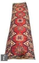 A Turkish Dosemealti runner, circa 1970s, with a series of seven central lozenges, red, blue and