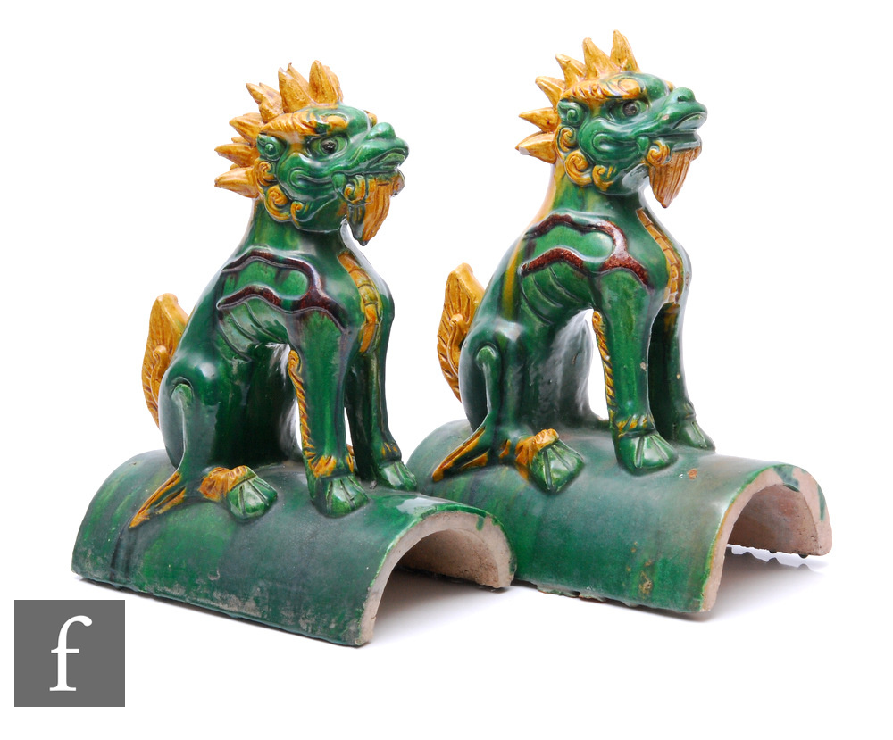 A pair of Ming Sancai styl roof tiles, the arched tile surmounted by a seated shishi lion, in
