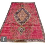 A Turkish Oushak rug, the red ground with central floral design picked out in ochre and blue,