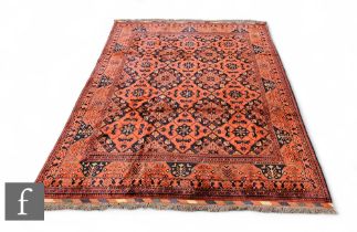 A Turkmen carpet, two rows of blue interspaced lozenges on a red ground within a running floral