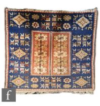 A Turkish Cannakkale woven wool prayer rug, the blue ground rug with central rectangular pink panel,