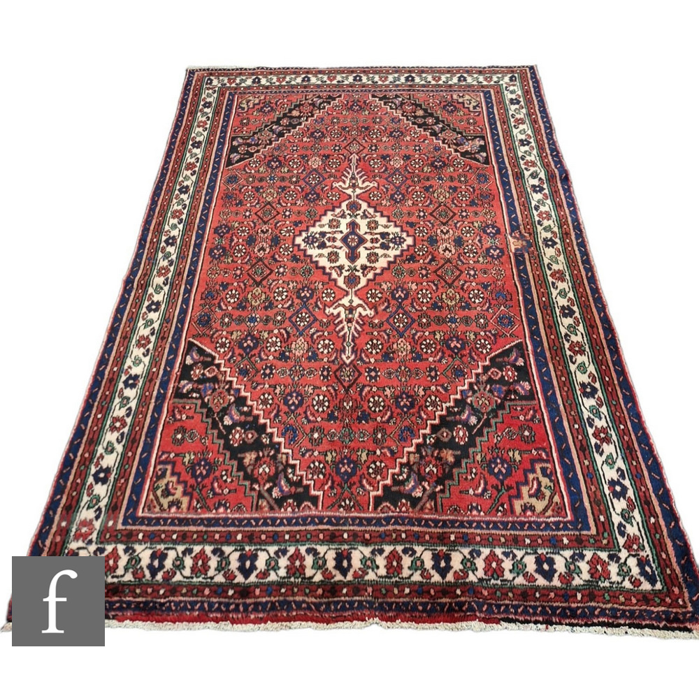 A Persian Hamadan rug, the red ground with central diamond shaped lozenge and scalloped black
