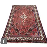 A Persian Hamadan rug, the red ground with central diamond shaped lozenge and scalloped black