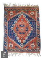 A Turkish Bergama Kuba woven wool rug, circa 1950s/60s, the red and blue ground with central diamond
