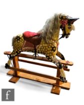 A large early 20th Century carved wooden sectional rocking horse, painted in dapple yellow and black