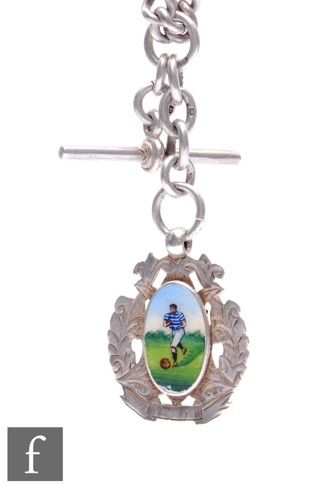 A silver Albert watch chain with T bar and enamelled pendant of a footballer kicking a leather ball,