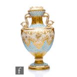 A Coalport porcelain 'Jewelled' pedestal vase, circa 1900, the ivory ground heavily enamelled with