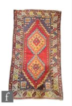 A Turkish Ortakoy woven wool rug, circa 1960, the red ground rug with central diamond lozenge,