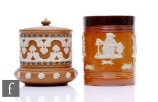 Two Doulton stoneware tobacco jars and covers, each decorated with relief moulded figural and floral