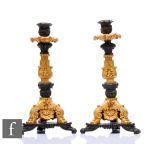 A pair of French Empire style bronze and ormolu cast bronze candlesticks, scroll feet and tricorn