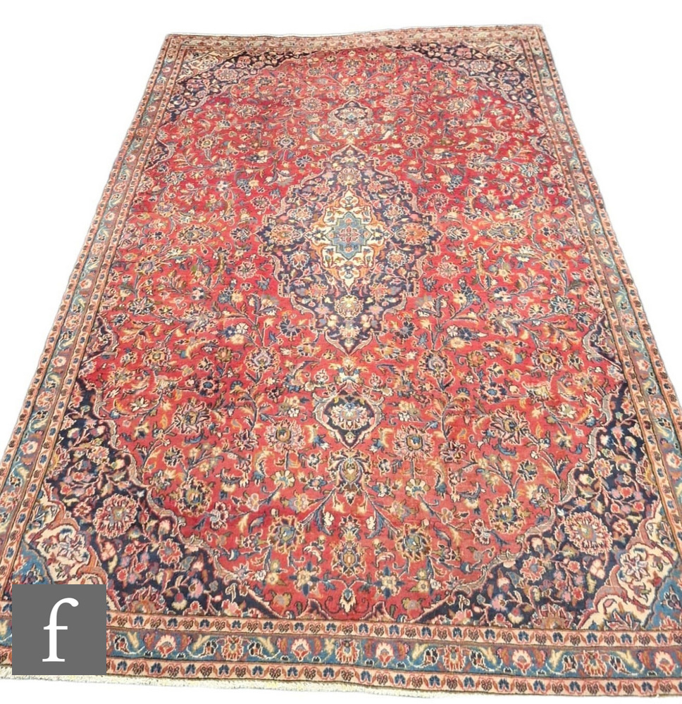 A large Persian Corcoran wool carpet, with central floral shaped lozenge surrounded by blue ochre