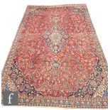 A large Persian Corcoran wool carpet, with central floral shaped lozenge surrounded by blue ochre