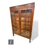 A large 19th Century oak bookcase enclosed by a pair of double bar glazed doors on separate stand,