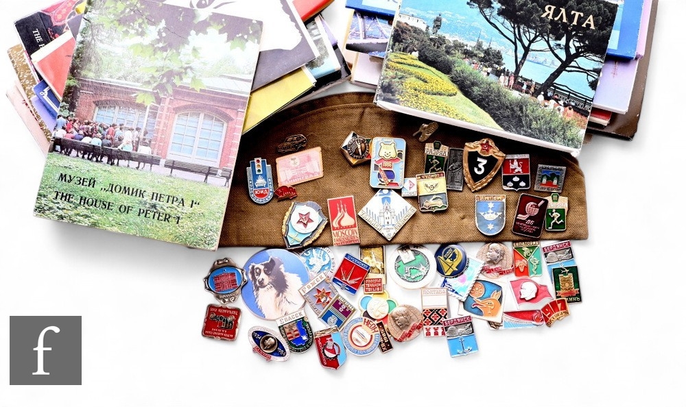 A collection of post 1950s Russian enamel badges, a hat with patches and badges and a quantity of