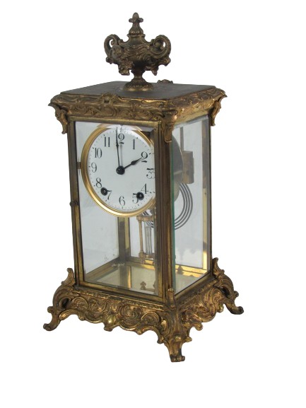 An early 20th Century American ormolu Mantle Clock, the top with ornate urn finial, the main body