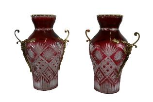An attractive pair of cutglass ruby Vases, each with two brass scroll handles and a brass rim, 39cms
