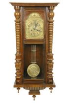 A Vienna beech Wall Clock, with arched brass dial and Arabic numerals and a circular brass