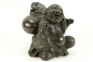 A heavy 19th Century Chinese bronze Figure of rotund Japanese Man, Hotri, seated with a backpack,