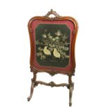 A cartouche shaped Victorian mahogany cheval Firescreen, with stump work and needle work panel on