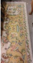 A large cream ground heavy woollen Carpet, with central floral panel and shaped similar decorated
