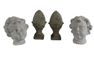 A pair of moulded chalk models of Cherub Heads, 22cms (8 1/2") a pair of moulded plaster pineapple