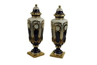 A pair of relief moulded dark blue and white porcelain Urns and fixed covers, and gilt decoration