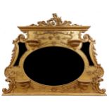 An ornate gilt and gesso Overmantel, with leaf scroll and floral crest above a large oval bevelled