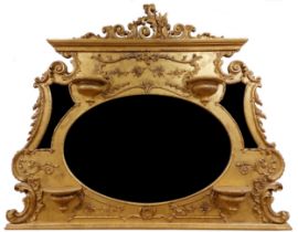 An ornate gilt and gesso Overmantel, with leaf scroll and floral crest above a large oval bevelled