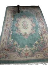 An attractive heavy woollen Chinese green ground floral decorated Carpet, approx. 253cms x 172cms (