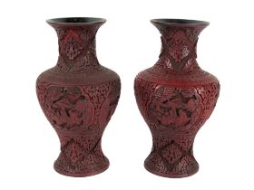 A pair of 19th Century Chinese cinnabar baluster shaped Vases, with landscape and figural panels,