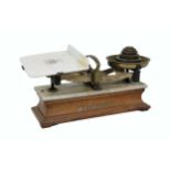 An Edwardian W. & T. Avery Weighing Scales, with weights, porcelain balance on an oak base. (1)