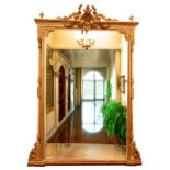 A monumental Victorian giltwood Overmantel Mirror, the cornice with central shield and floral