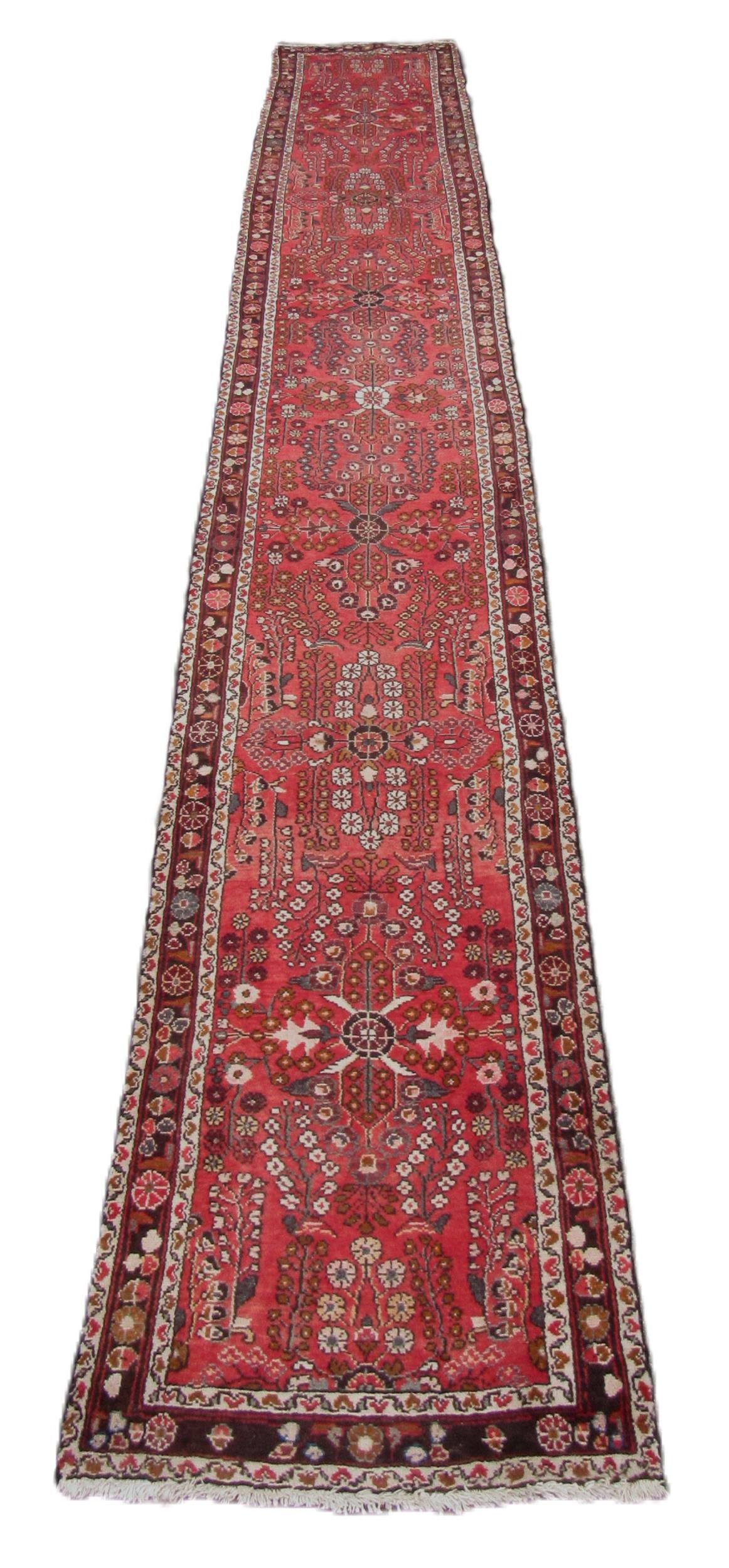 A semi-antique Middle Eastern woolen Carpet Runner, the burgundy ground multi-floral centre inside a