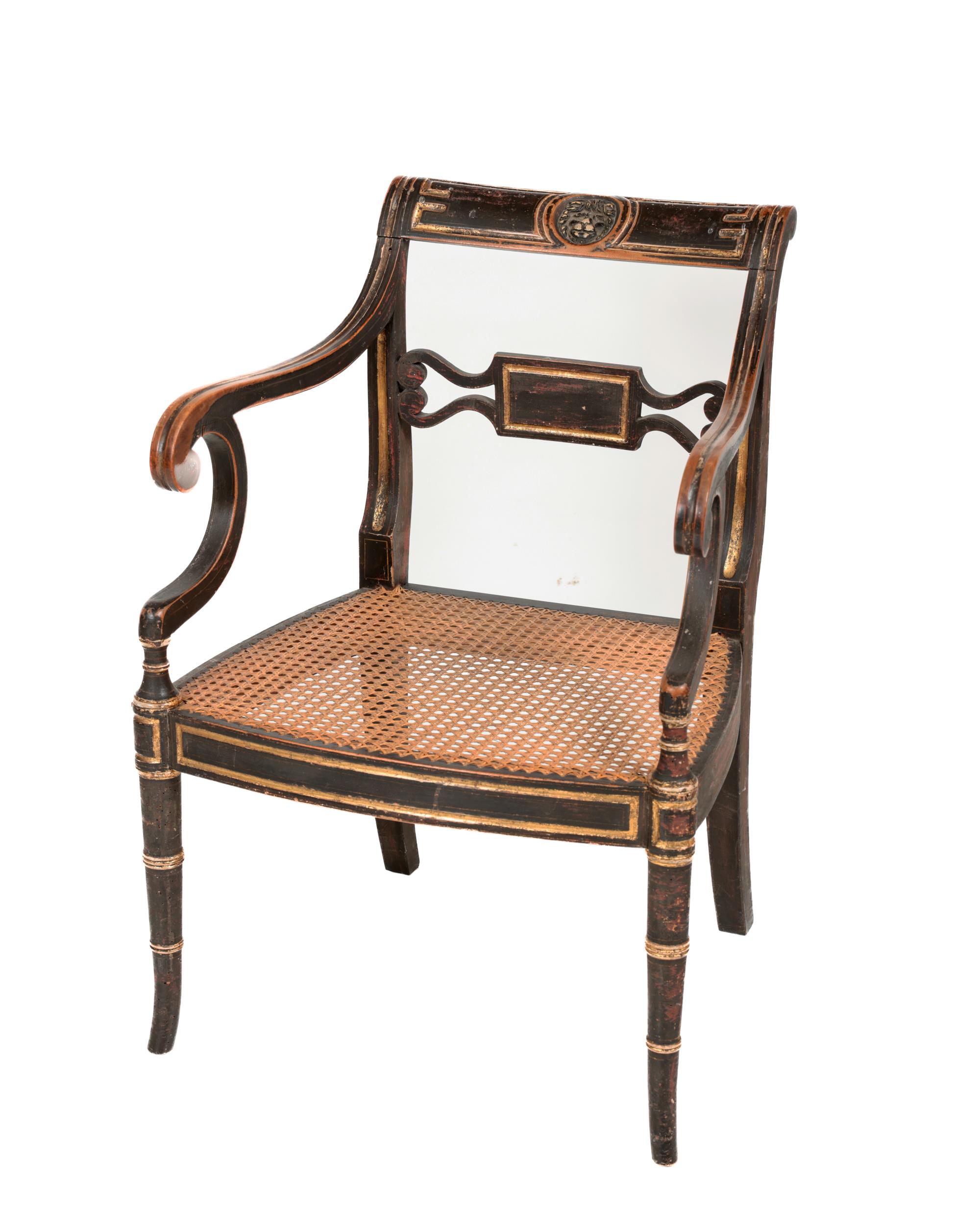 A Regency ebonised Open Armchair, the shaped back with central carved lions head, with scroll