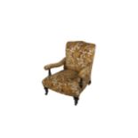 A Victorian mahogany framed Low Armchair, covered in floral brocade in the manner of Howard, on
