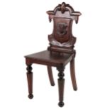 A Victorian mahogany shield back Hall Chair, with carved back over solid seat on front octagonal