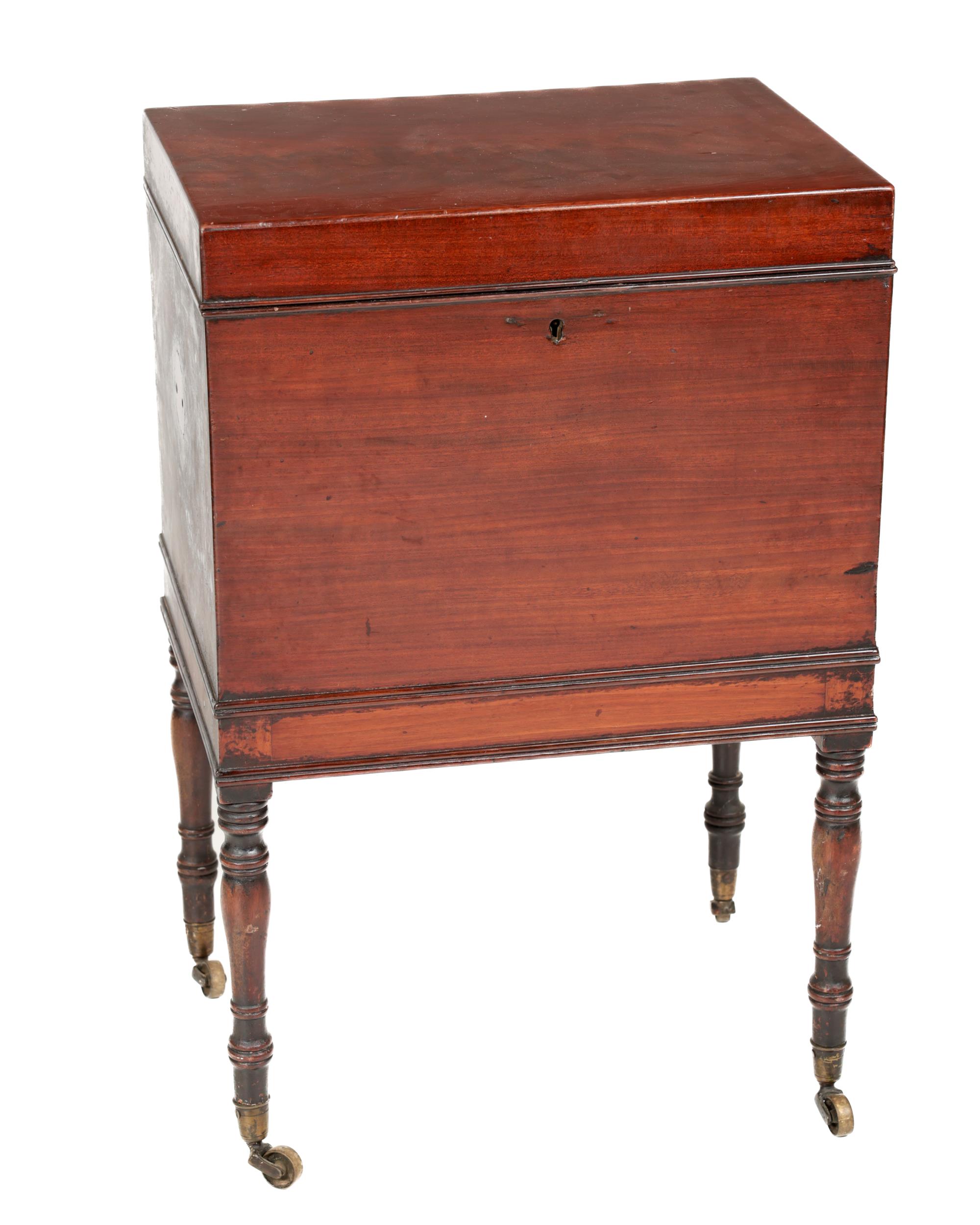 A Georgian period mahogany Tea Caddy, on stand, the lift top opening to reveal metal lined