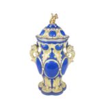 A large attractive English porcelain two handled blue ground cream decorated Urn and Cover, the