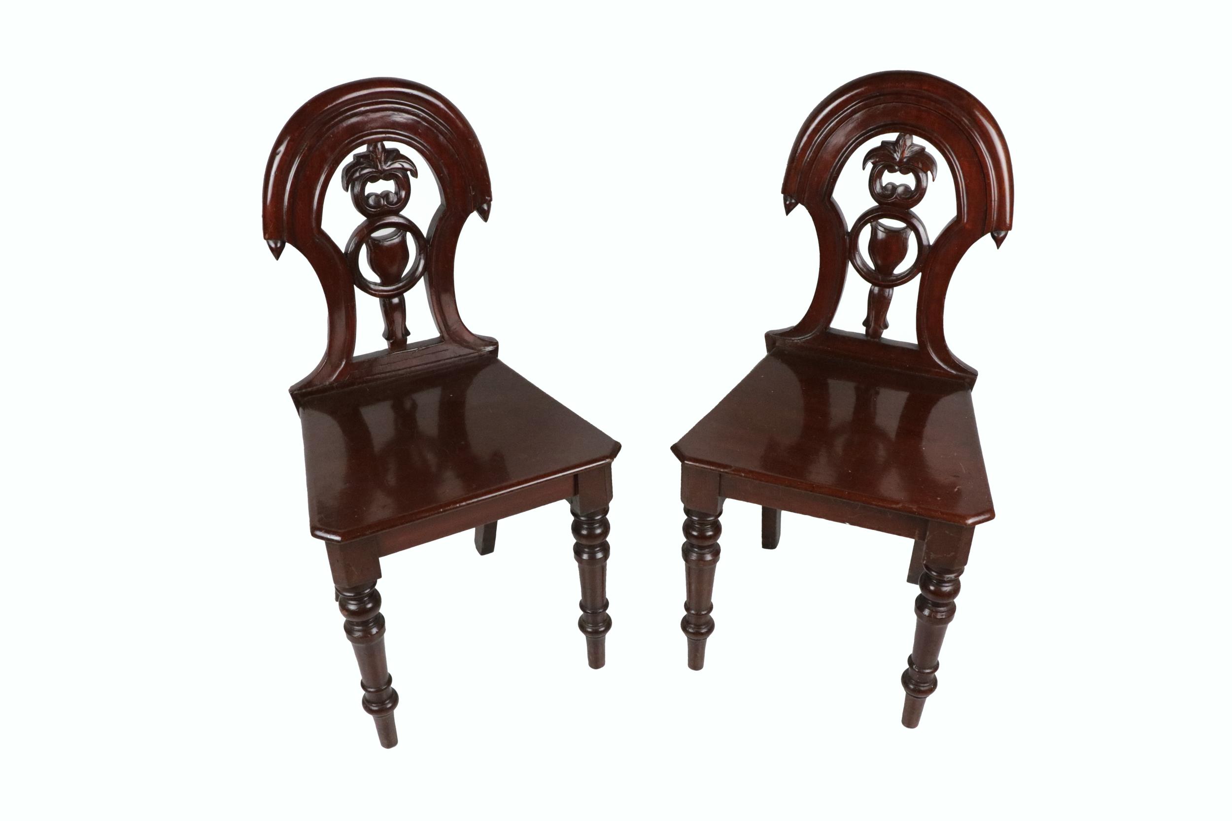 A pair of Victorian mahogany shield back Hall Chairs, each with pierced splat back over shaped