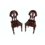 A pair of Victorian mahogany shield back Hall Chairs, each with pierced splat back over shaped